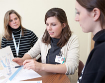 Genetic counselor Laura Birkeland, MS, CGC (left) observes first-year genetic counseling intern Sarah Hamilton (center) in the clinic.